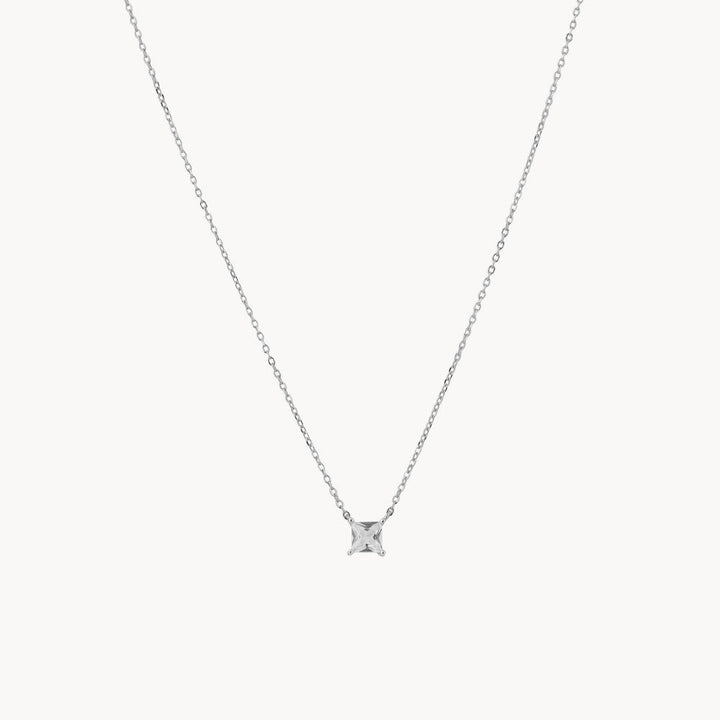 A delicate gold chain necklace with a single solitaire diamond pendant in a four-prong setting
